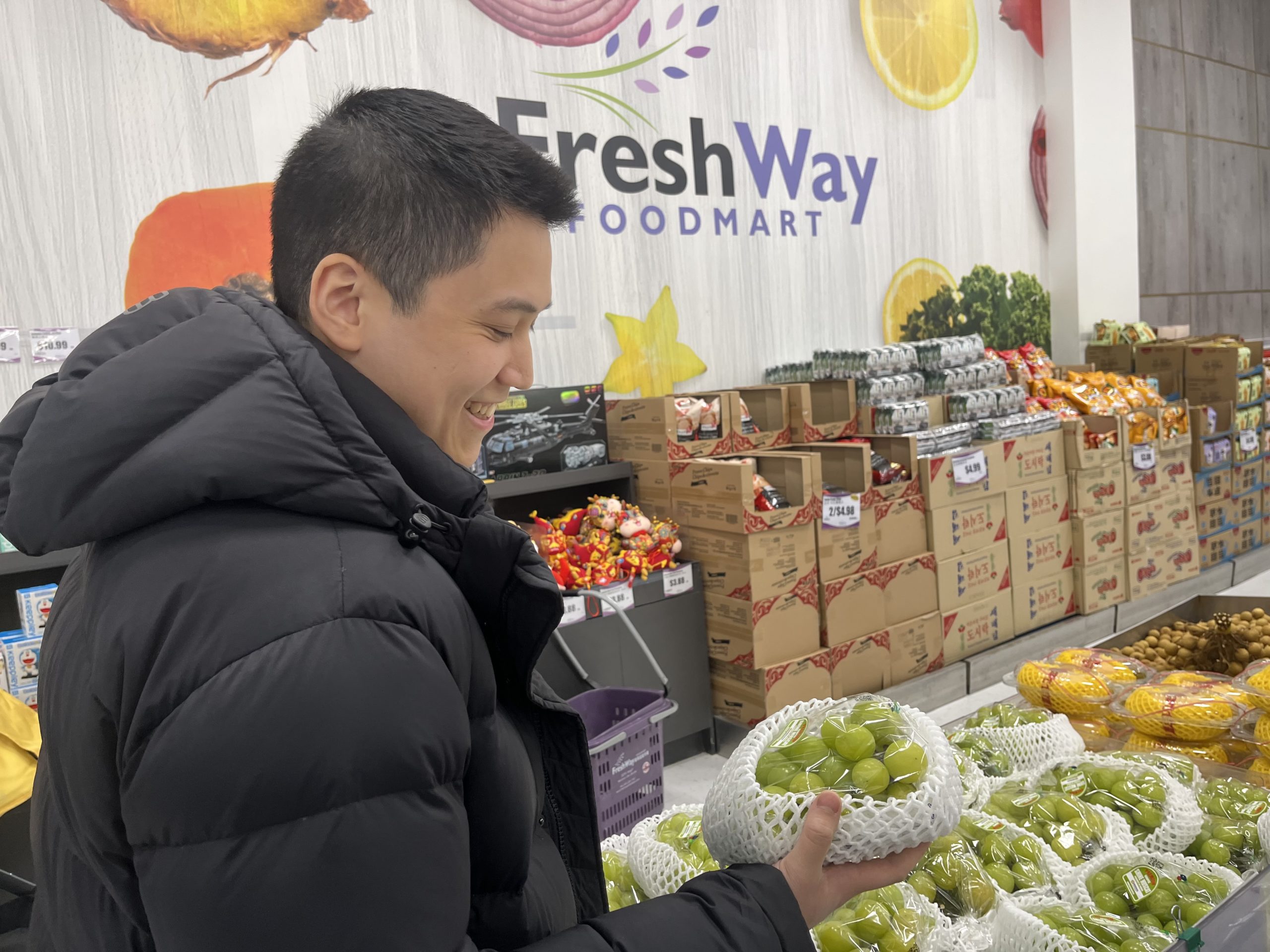 Braden Chong inspects some green grapes at Fresh Way Foodmart