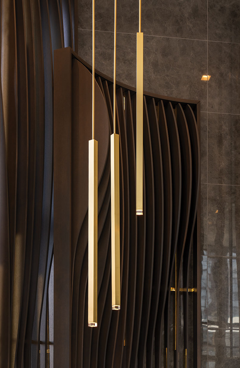 The most dramatic feature in the Willowdale lobby is the curvilinear screen—a series of vertical wooden fins embedded in a layer of brass—behind the concierge desk